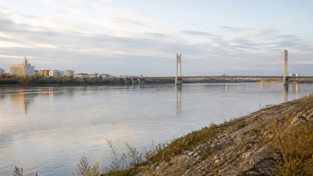 Conceptual early-morning Semey riverfront with the Irtysh, a cable-supported bridge and a restrained city skyline