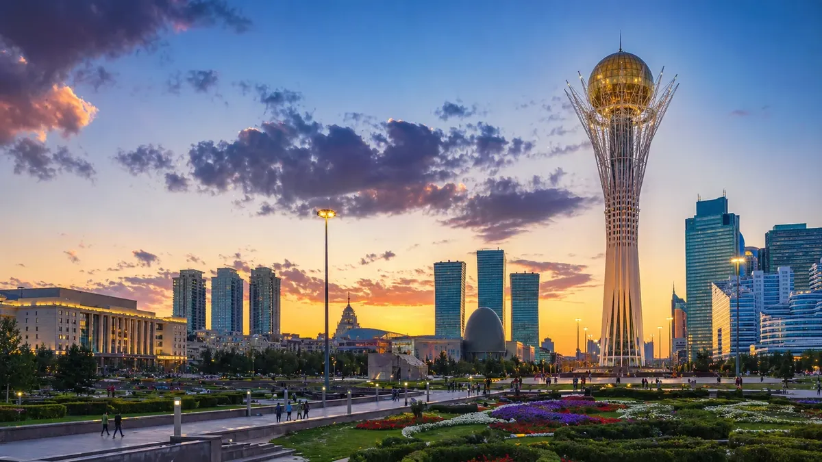 Bayterek Tower and the modern Astana skyline at sunset