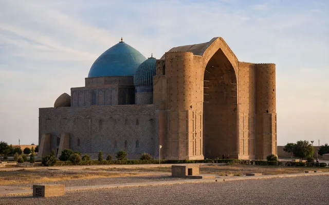 Conceptual early-morning view of the Khoja Ahmed Yasawi Mausoleum in Turkistan with brick walls and blue-tiled domes