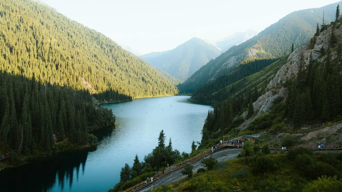 Crystal-clear turquoise waters of Kolsai Lake surrounded by Tian Shan spruce forests