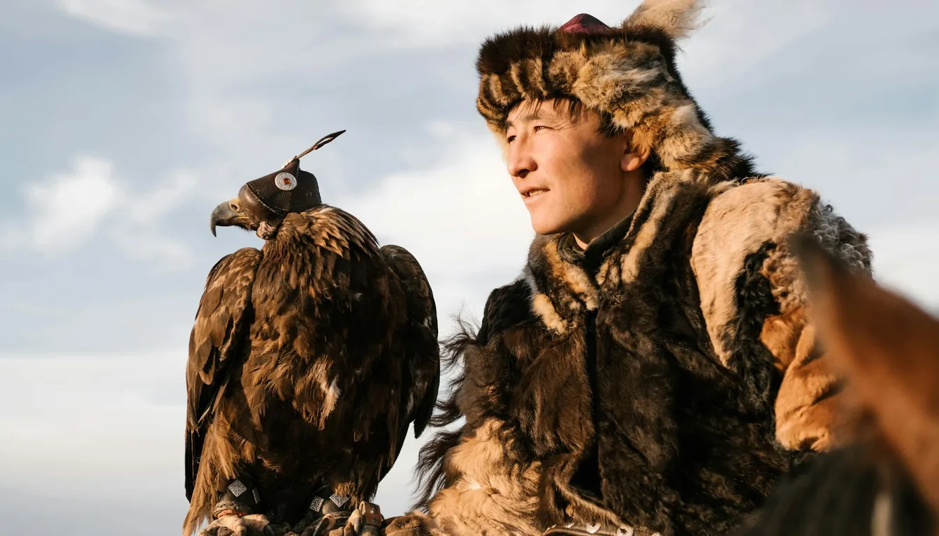 Kazakh berkutchi eagle hunter on horseback with golden eagle on glove