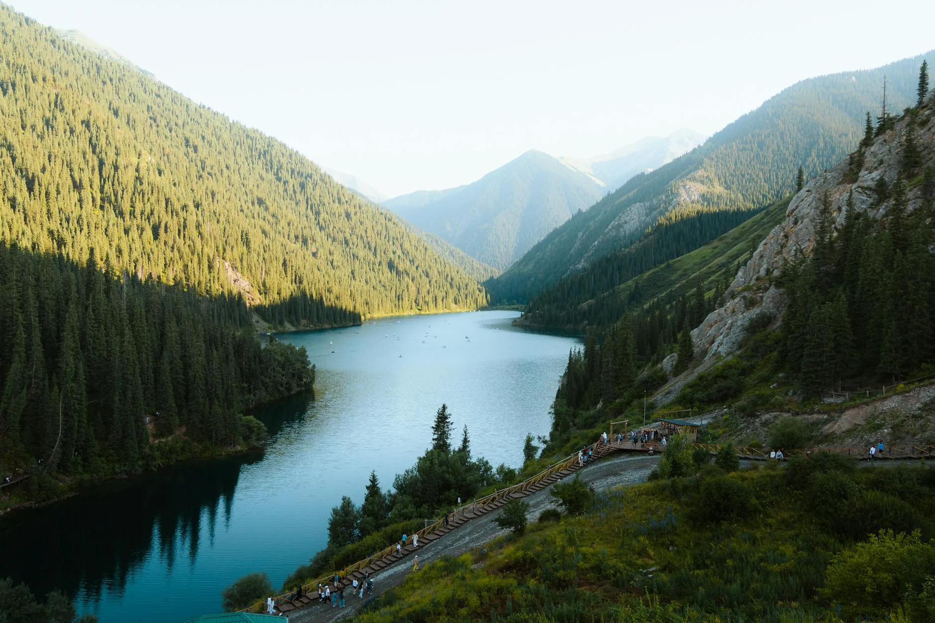 Crystal-clear turquoise waters of Kolsai Lake surrounded by Tian Shan spruce forests