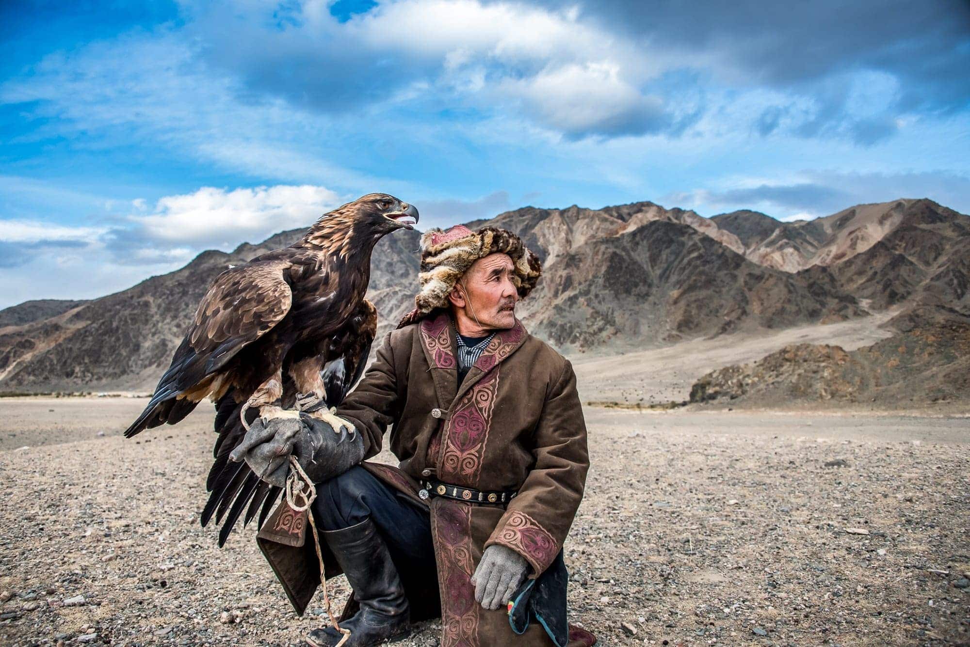 Kazakh hunter holding a trained eagle during a traditional hunting expedition in Kazakhstan