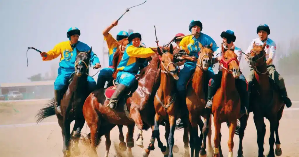 Group of Kazakh horsemen fiercely competing in a traditional game of kokpar, a sport deeply rooted in the nomadic culture of the Kazakh Khanate. The players, dressed in vibrant colors, ride their horses while trying to gain control of a goat carcass, symbolizing strength, skill, and unity that were central to the lifestyle of the Kazakhs during the Khanate era.